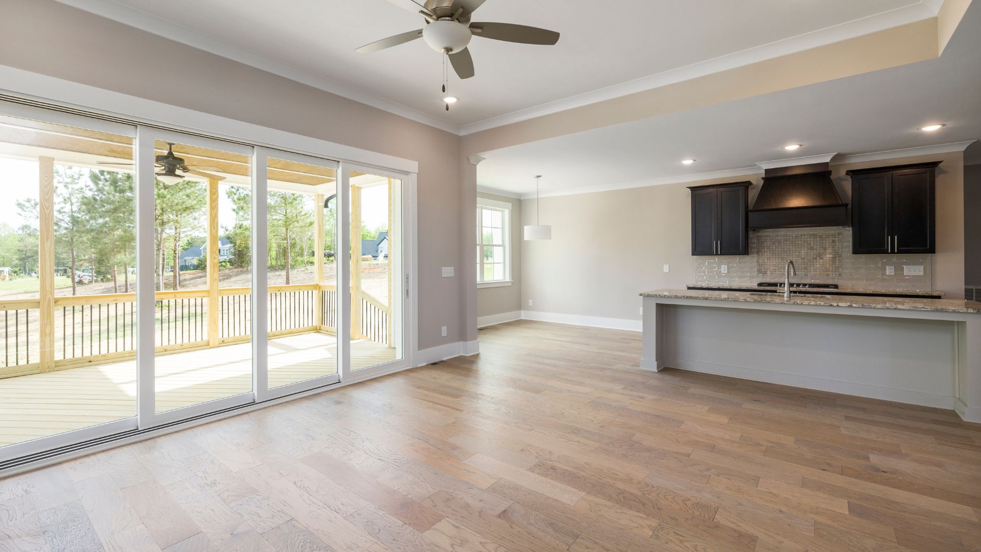 An empty kitchen and living room with sliding glass doors