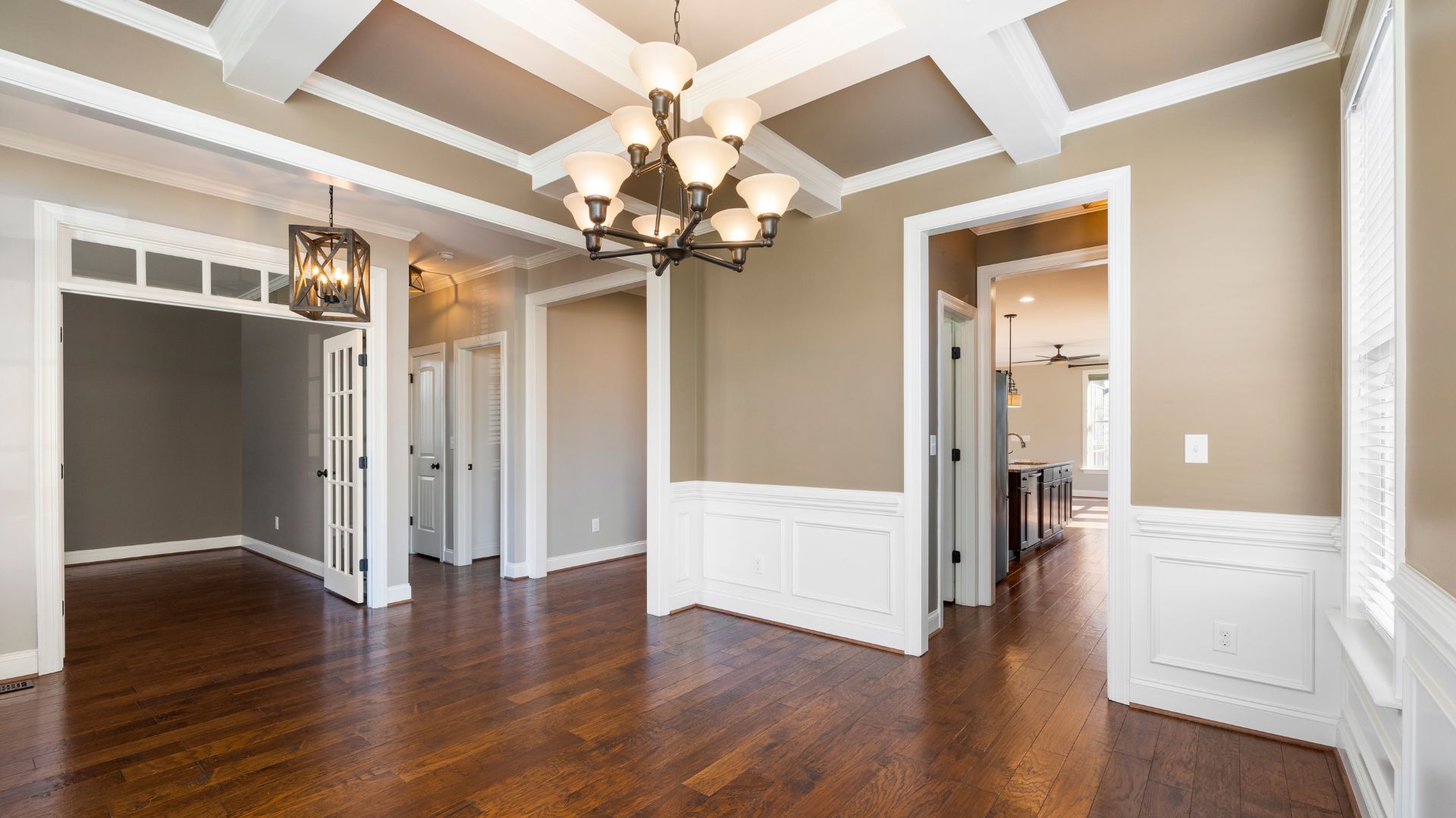 An empty room with hard wood floors and a chandelier