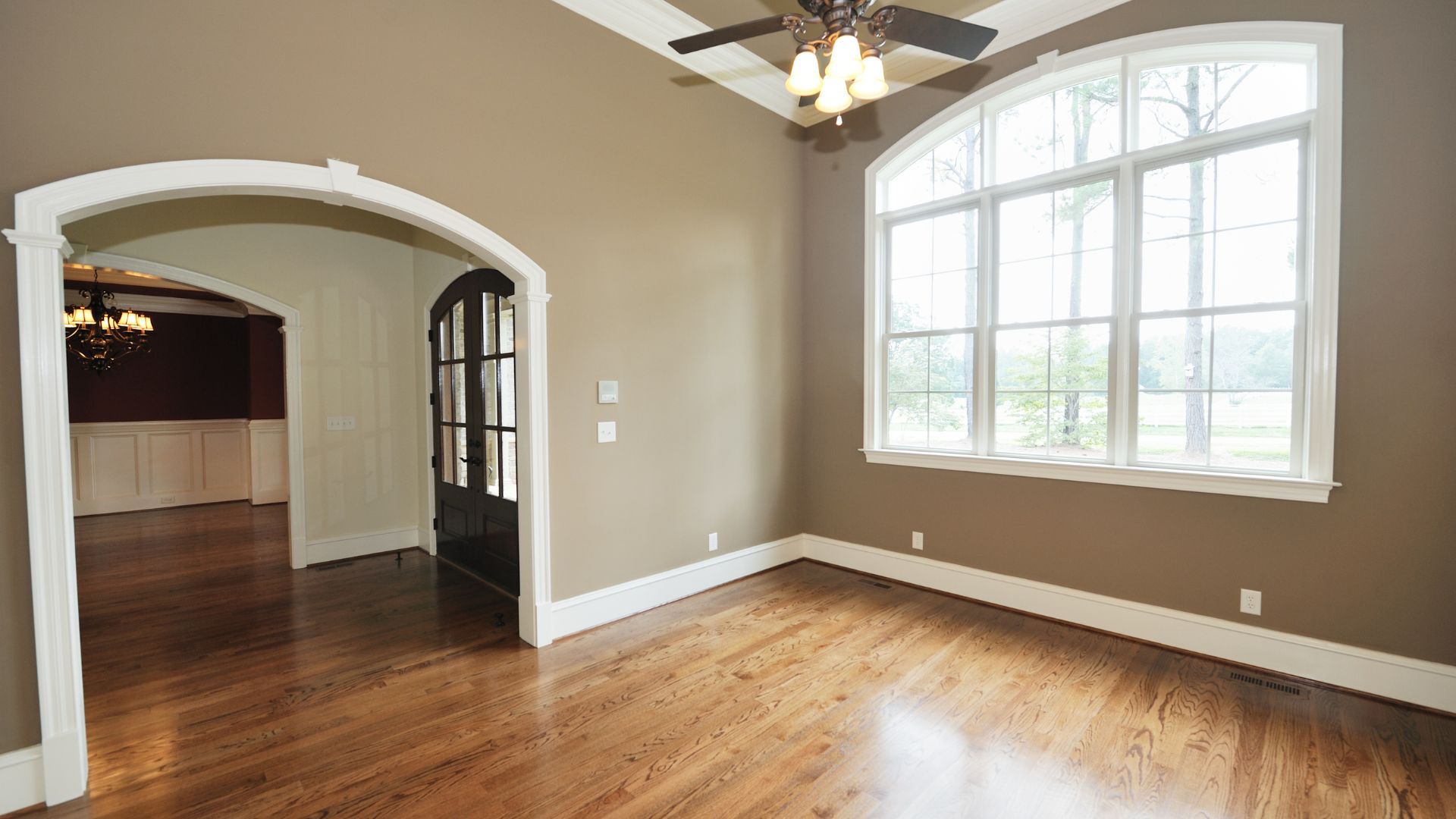 A large empty room with a ceiling fan