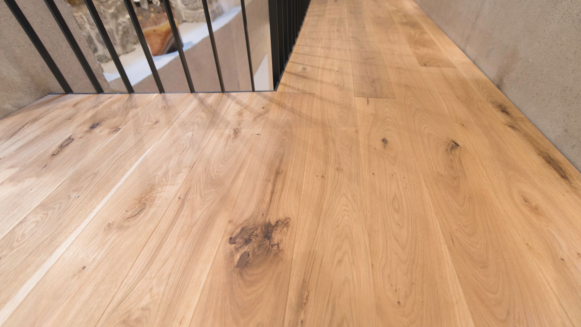 A wooden floor in a room with a metal railing